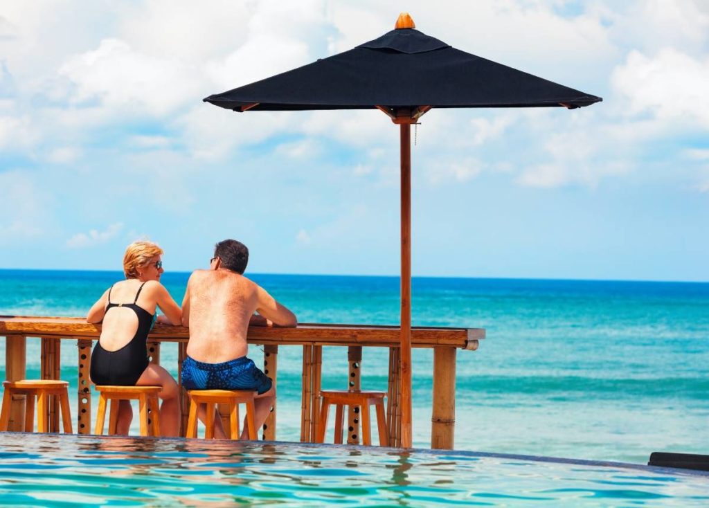 retired couple on beach enjoying early retirement