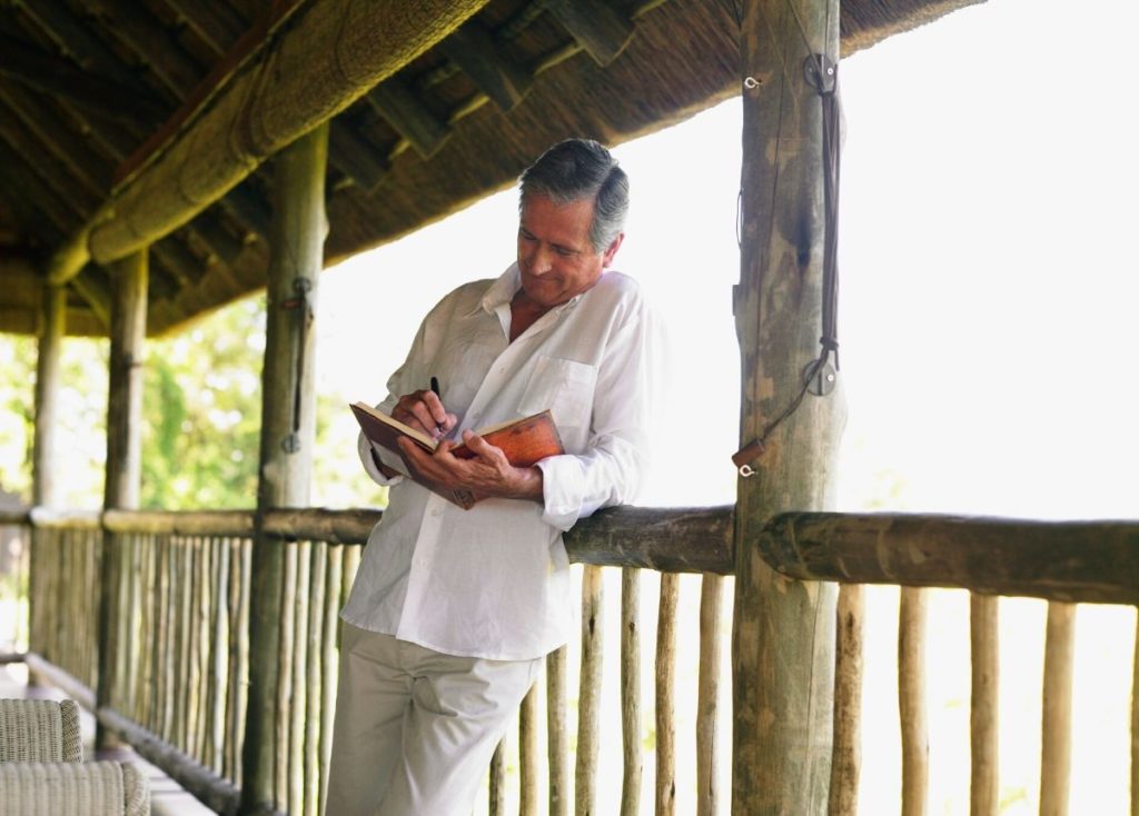 Senior male journaling on porch